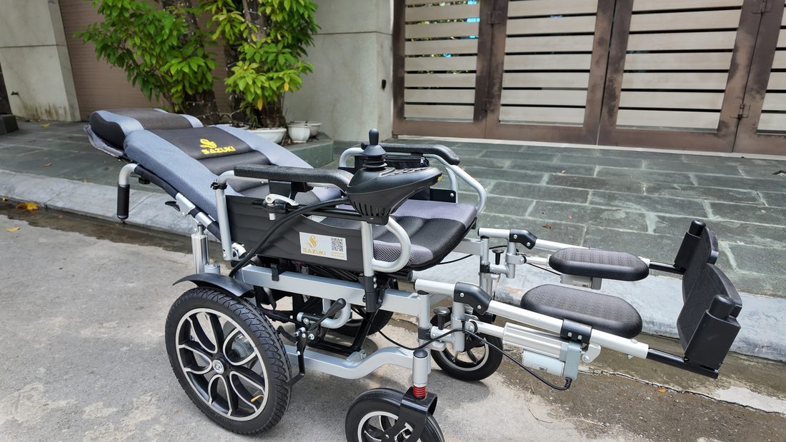 Xe lăn điện ngả nằm hạ phẳng lưng và nâng gác chân ngoài đời thực trước cổng nhà